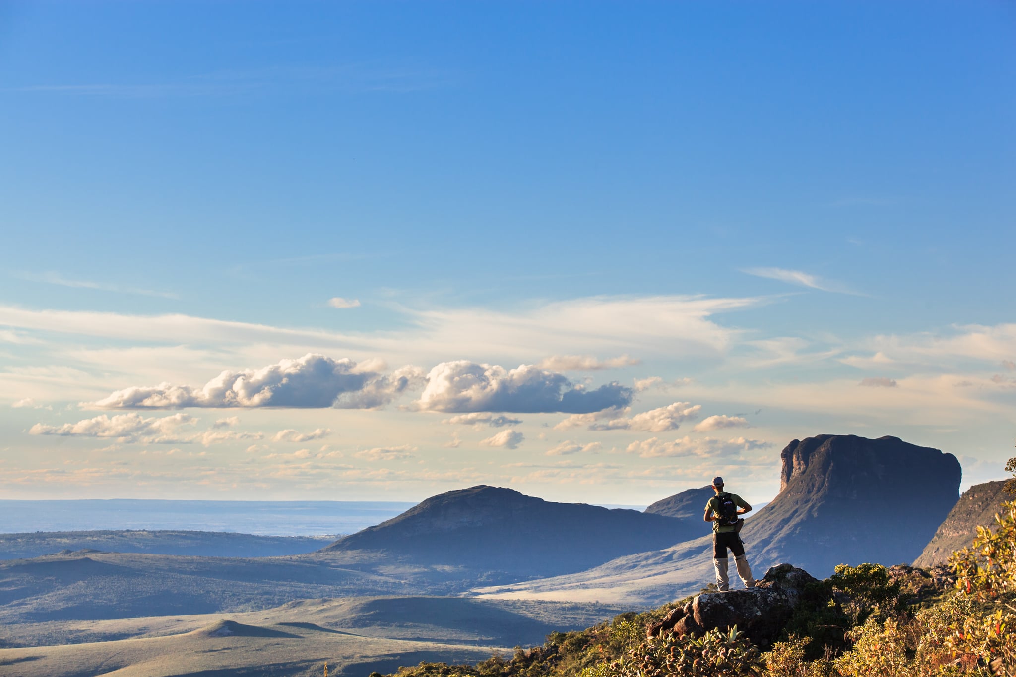Trekker contemplando os vales e o Morrão na Chapada Diamantina ao fim da tarde